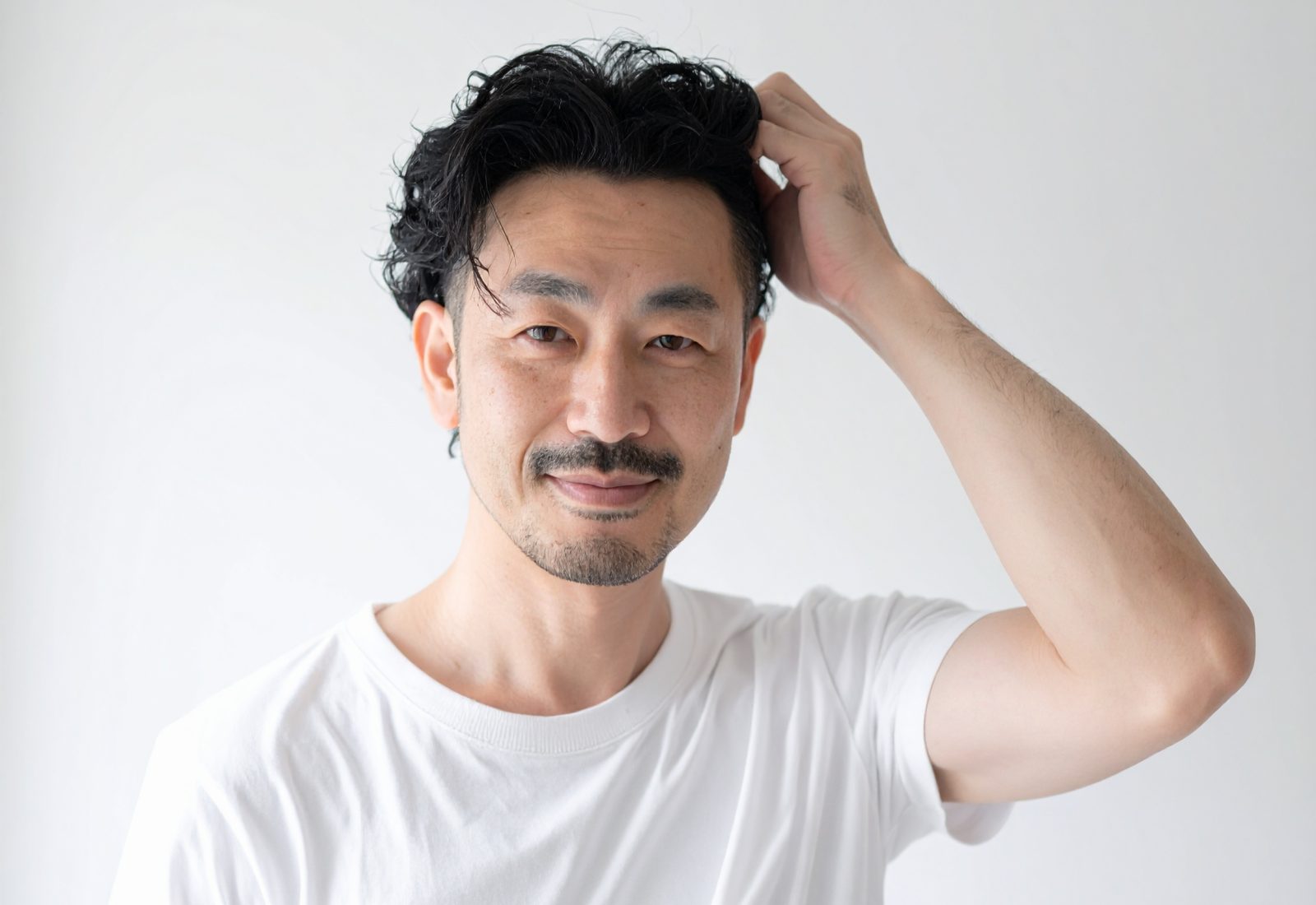 Firefly_爽やかな日本人男性が髪の毛を触っている画像、男性の周りは少し余白つけて 968435
